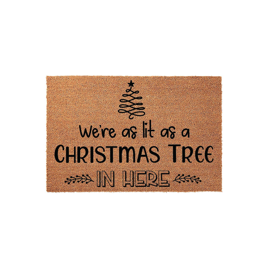 Funny Christmas doormat featuring a natural coir texture with black text that reads We are as lit as a Christmas tree in here, accented by a simple line-art tree graphic and decorative leaf flourishes on a plain white background.