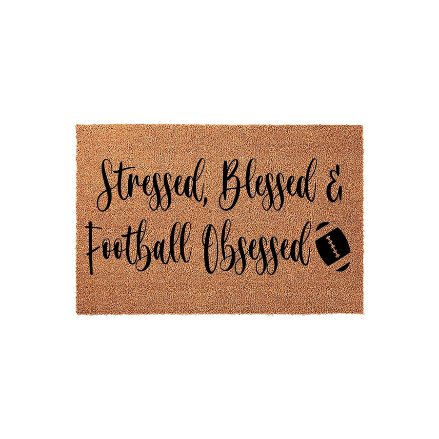 Stressed Blessed and Football Obsessed coir doormat featuring bold black cursive lettering and a small football graphic on a natural tan textured background, perfect for a sports fan entryway or a front porch decor update.