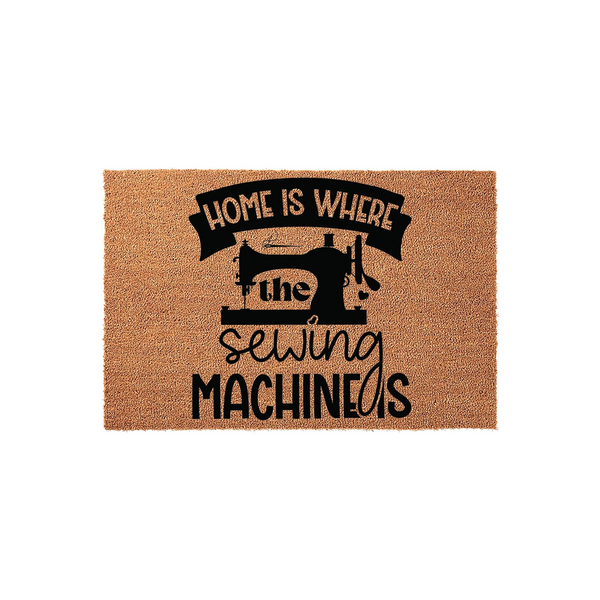 Home Is Where The Sewing Machine Is coir doormat featuring a black silhouette of a vintage sewing machine and bold typography, set against a natural brown textured fiber background for a charming craft room or entryway decor