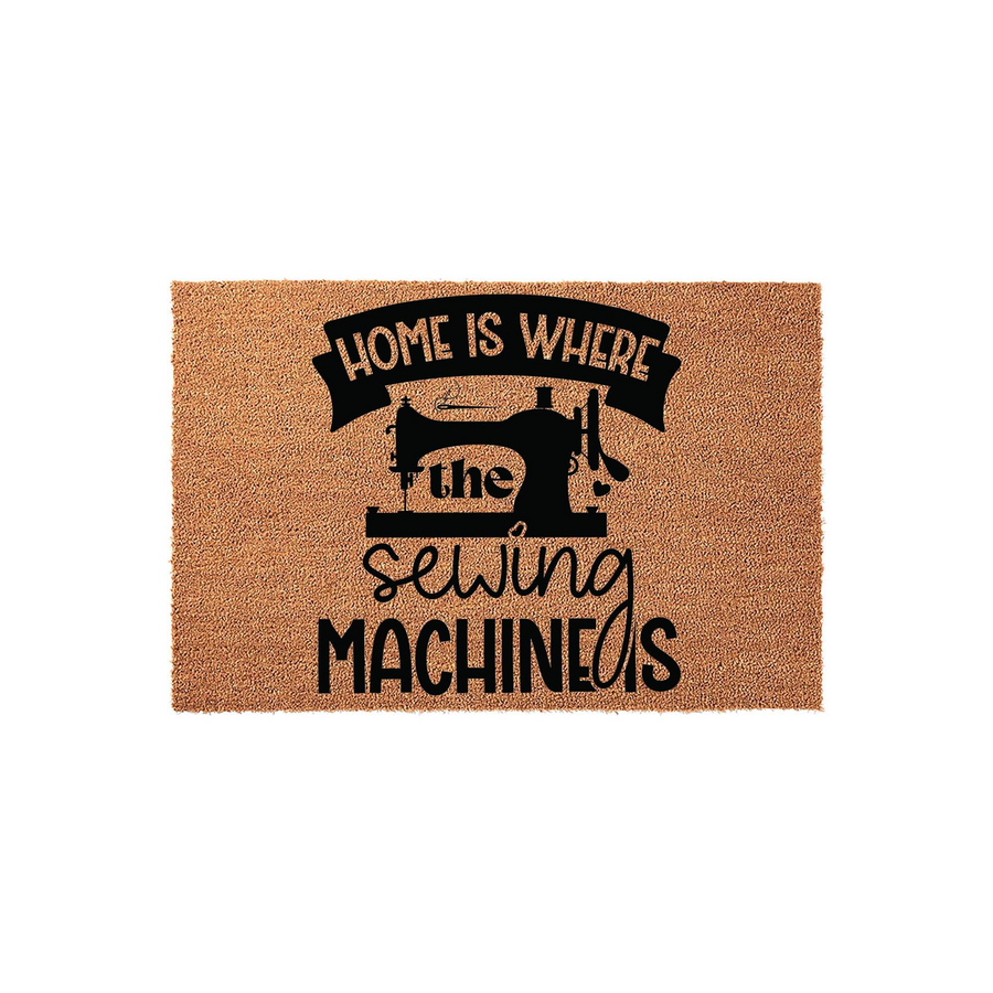 Home Is Where The Sewing Machine Is coir doormat featuring a black silhouette of a vintage sewing machine and bold typography, set against a natural brown textured fiber background for a charming craft room or entryway decor