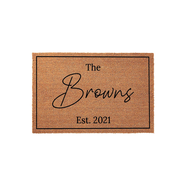Personalized family name coir doormat featuring a classic rectangular border, elegant script lettering for the last name, and the established year printed in a clean serif font on a natural tan fiber background for a front porch.
