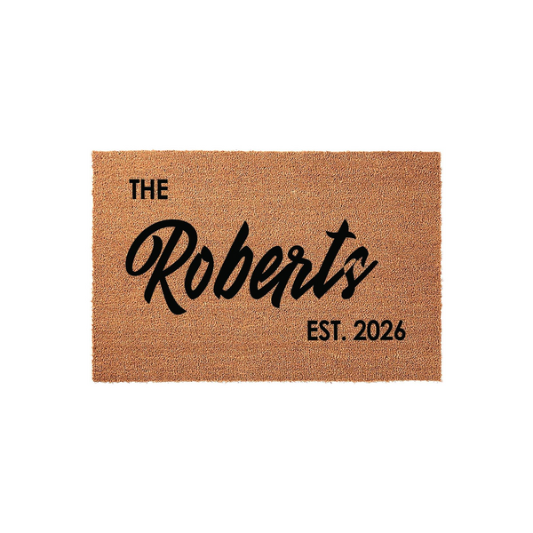 Personalized family name coir doormat featuring a natural tan fiber texture with bold black lettering that displays a custom last name and an established year, creating a welcoming entrance for any home or front porch decor.