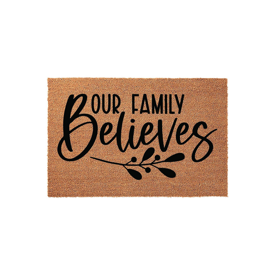 Our Family Believes coir doormat featuring a natural tan fiber texture and bold black script lettering with a decorative leaf sprig design, providing a welcoming and rustic touch to your front porch entryway decor.