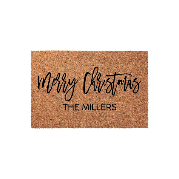 Personalized Merry Christmas coir doormat featuring a natural brown fiber texture with black script lettering and a custom family name printed in a clean sans-serif font, creating a festive holiday welcome for your front porch