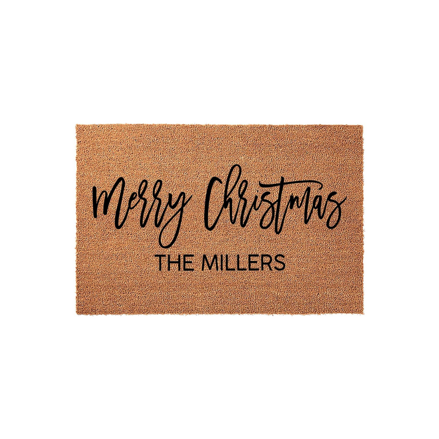 Personalized Merry Christmas coir doormat featuring a natural brown fiber texture with black script lettering and a custom family name printed in a clean sans-serif font, creating a festive holiday welcome for your front porch