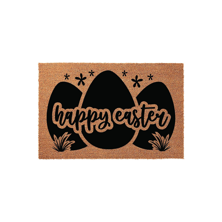 Happy Easter coir doormat featuring a trio of large black egg silhouettes decorated with small flowers and grass accents, set against a natural brown textured fiber background for a festive spring entryway decor display.