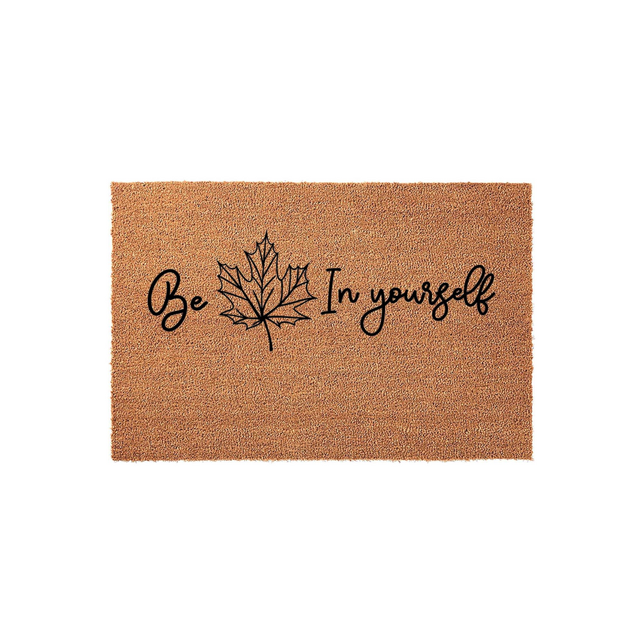 Fall Maple Leaf Welcome Doormat featuring the inspirational phrase Be Leaf In Yourself written in elegant black script, centered on a natural brown coir fiber mat against a clean white background for a cozy autumn porch aesthetic.
