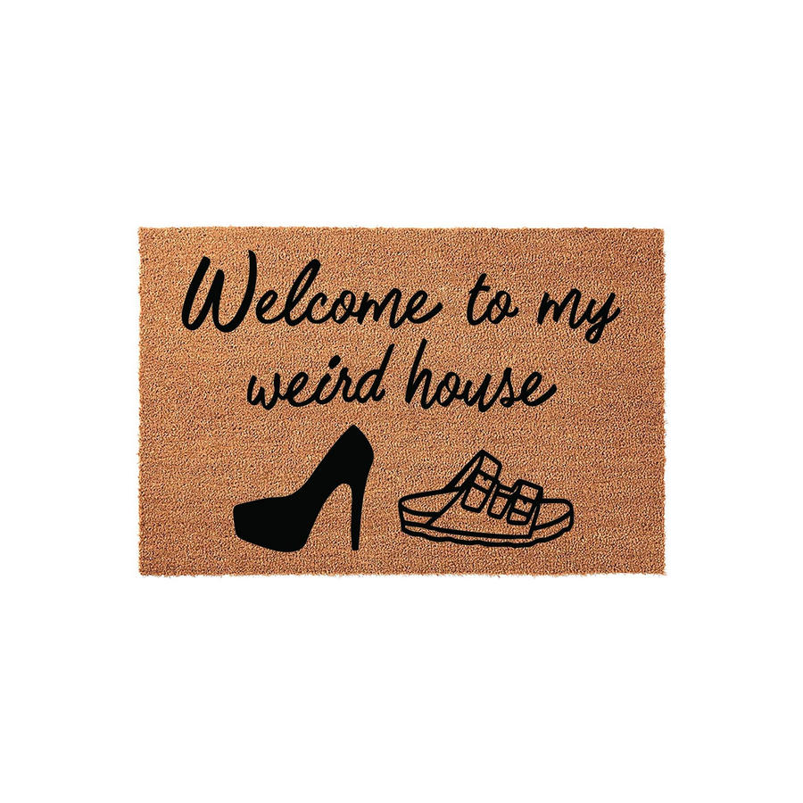 Welcome to my weird house coir doormat featuring black text and illustrations of a high heel shoe and a sandal, set against a natural brown fiber background to add a humorous and welcoming touch to your front porch entryway decor.