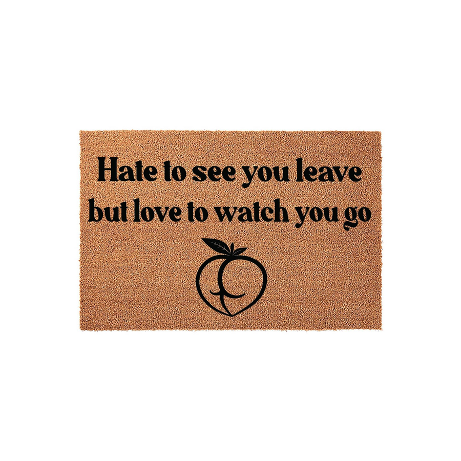 Funny doormat with the text Hate to see you leave but love to watch you go printed in black ink above a stylized peach icon, featuring a natural coir fiber texture on a plain white background for a humorous front porch entryway