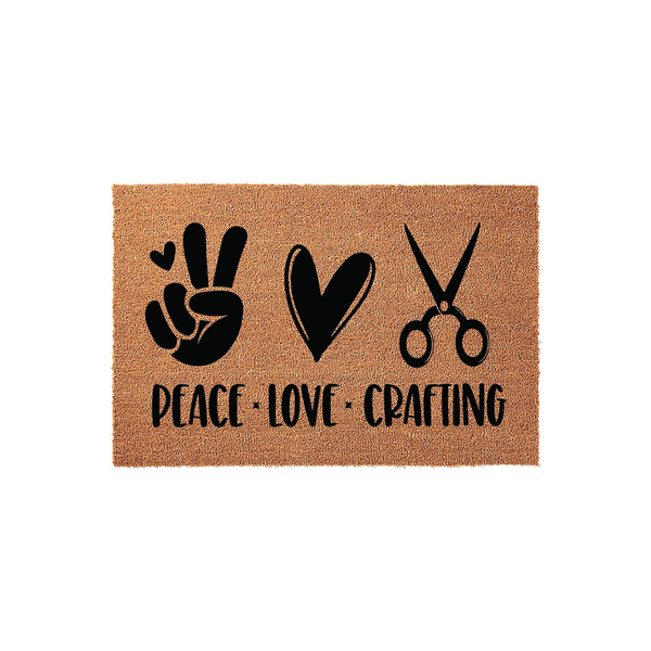 Peace Love Crafting coir doormat featuring a black printed design of a peace sign, a heart, and a pair of scissors on a natural tan textured background, making it a fun entryway accessory for any dedicated crafter or hobby room.