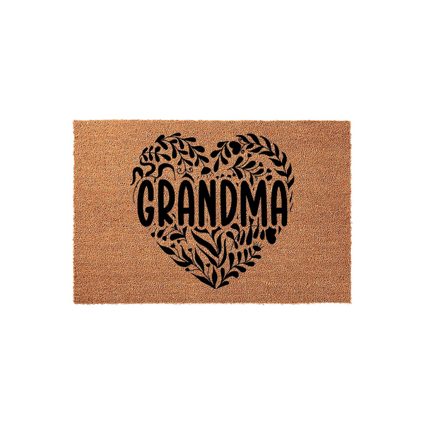 Grandma coir doormat featuring a large, black heart-shaped design filled with intricate botanical leaf illustrations, centered on a natural tan fiber background to welcome guests to a home with a warm and rustic aesthetic.