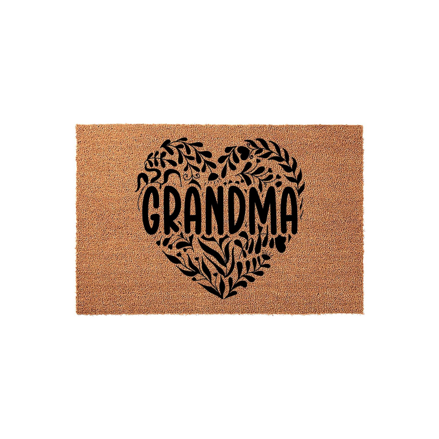 Grandma coir doormat featuring a large, black heart-shaped design filled with intricate botanical leaf illustrations, centered on a natural tan fiber background to welcome guests to a home with a warm and rustic aesthetic.