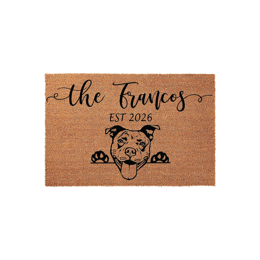 Personalized Pit Bull doormat featuring a natural coir texture with a black printed illustration of a happy Pit Bull dog peeking over the edge, customized with a family name and established year on a clean white studio background.
