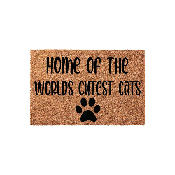 Home of the Worlds Cutest Cats coir doormat featuring a natural brown fiber texture with bold black lettering and a single paw print icon, making it a fun and welcoming entrance rug for any cat lover's home decor.