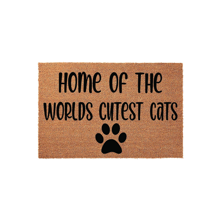 Home of the Worlds Cutest Cats coir doormat featuring a natural brown fiber texture with bold black lettering and a single paw print icon, making it a fun and welcoming entrance rug for any cat lover's home decor.