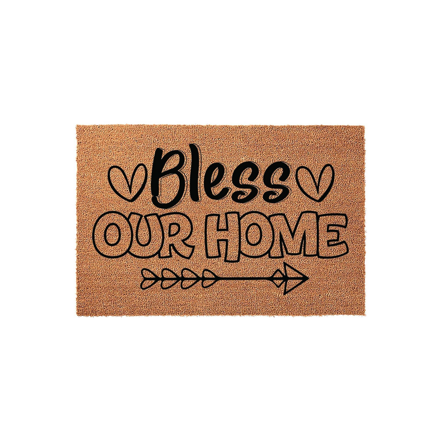 Bless Our Home coir doormat featuring a natural brown fiber texture with black printed text, decorative heart accents, and a stylized arrow graphic centered on a clean white background for a welcoming front porch entryway decor.
