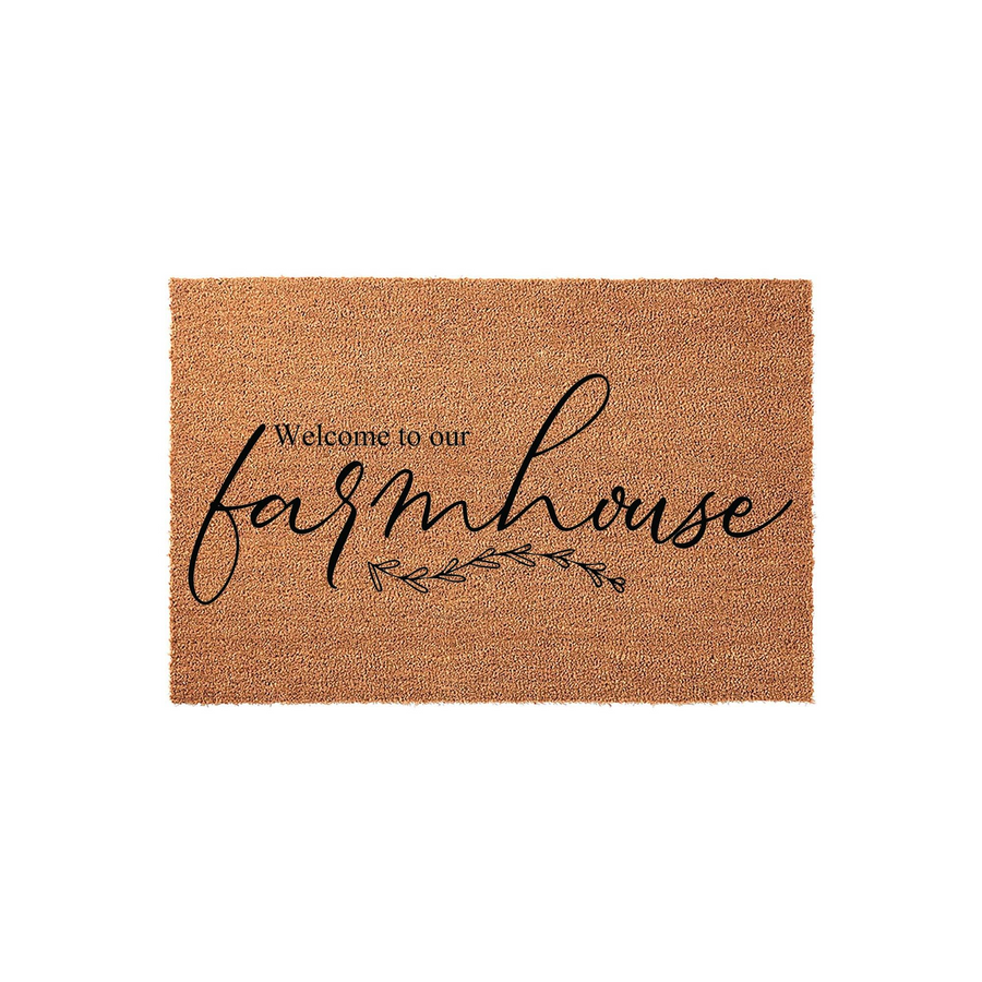 Farmhouse Welcome Doormat featuring a natural coir texture with black script lettering that reads Welcome to our farmhouse, accented by a delicate botanical leaf design centered on a clean, plain white studio background.