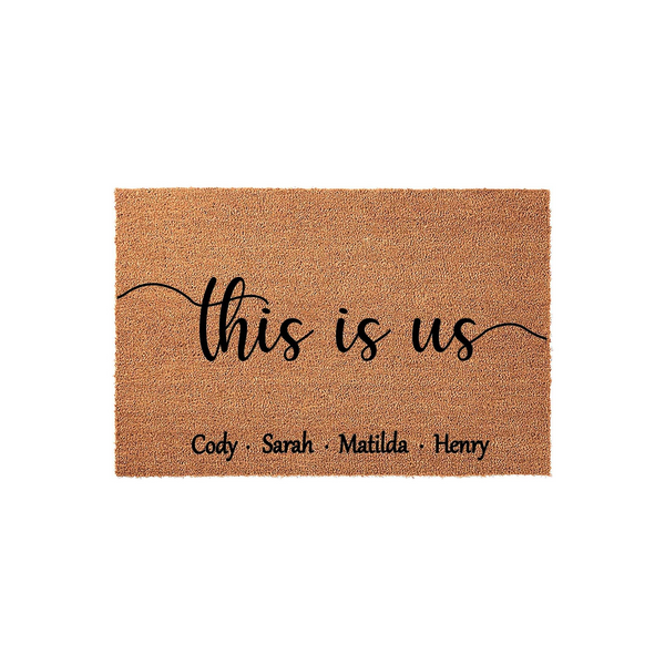 Personalized This Is Us family doormat featuring a natural coir texture with black script lettering and space for custom names, displayed against a clean white background for a modern home entryway or porch decor aesthetic.