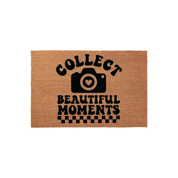 Collect Beautiful Moments photography doormat made of natural coir fiber, featuring a black camera icon with a heart lens and a checkered border design on a plain white background for a modern home entryway or photography studio