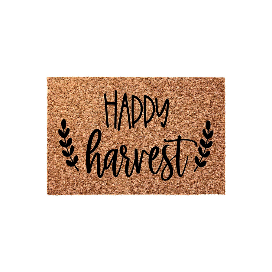 Happy Harvest coir doormat featuring black script lettering and decorative leaf sprigs on a natural brown fiber background, providing a festive seasonal welcome for your front porch entryway during the autumn months.