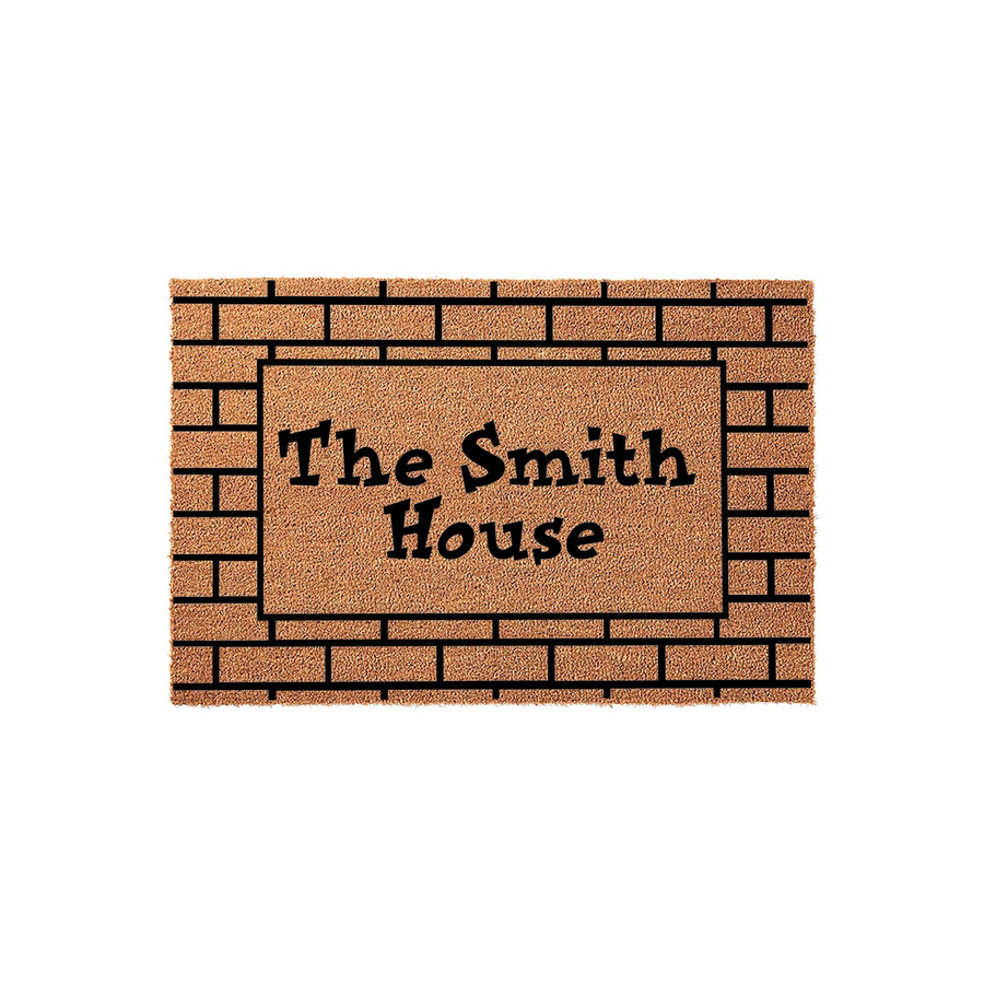 Personalized family name coir doormat featuring a rustic brick pattern border and bold black lettering that reads The Smith House, providing a durable and welcoming entrance mat for any front porch or home entryway decor.