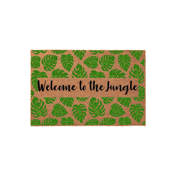 Welcome to the Jungle coir doormat featuring a vibrant pattern of green monstera leaves on a natural brown fiber background, with the text printed in a stylish black script across the center of this tropical outdoor entryway rug.