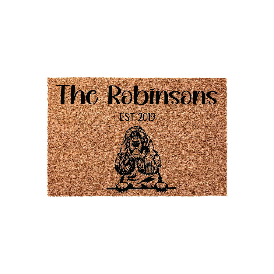 Personalized Cocker Spaniel coir doormat featuring a black illustration of a dog peeking over a line, with custom family name text and established year printed on a natural brown textured fiber background for a welcoming home