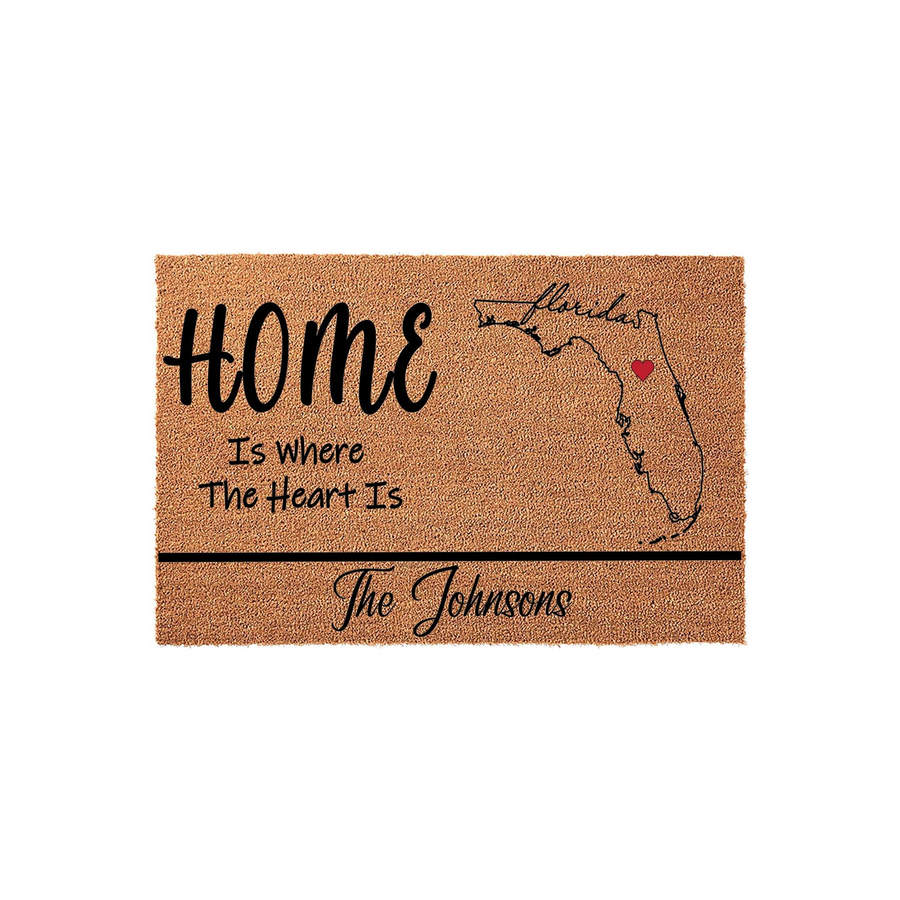 Personalized Florida state map coir doormat featuring the text Home Is Where The Heart Is with a red heart icon over the state, providing a custom entryway welcome mat for a family home on a clean white studio background.
