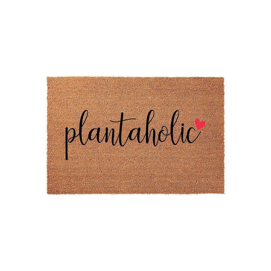 Plantaholic coir doormat featuring a natural brown fiber texture and bold black cursive lettering that reads plantaholic, accented by a small red heart icon on a clean white background for a modern home entryway decor aesthetic.