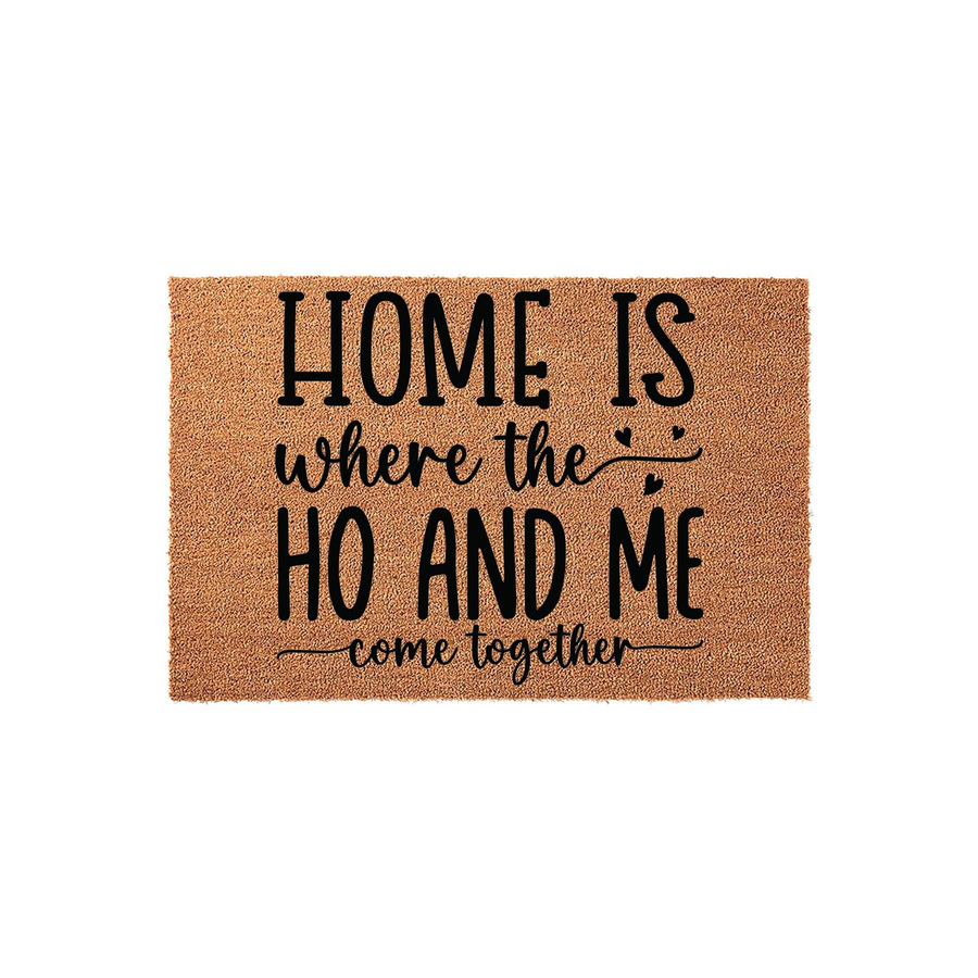 Funny Home Is Where The Ho And Me Come Together doormat made of natural coir fiber with a durable backing, featuring bold black typography and small heart accents on a textured brown surface for a humorous entryway decor