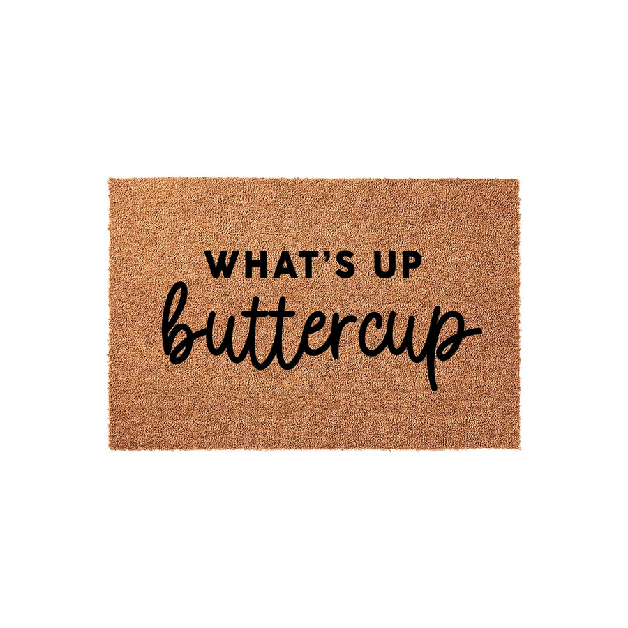 Whats Up Buttercup Coir Doormat featuring a natural tan fiber texture with bold black lettering that reads Whats Up Buttercup, providing a fun and welcoming entrance decor piece for your front porch or home entryway on a plain