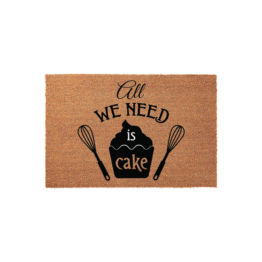All We Need Is Cake Doormat featuring a natural coir texture with black printed text and illustrations of a cupcake and two whisks, making a fun kitchen decor addition for any home baker who loves to spend time in the kitchen.