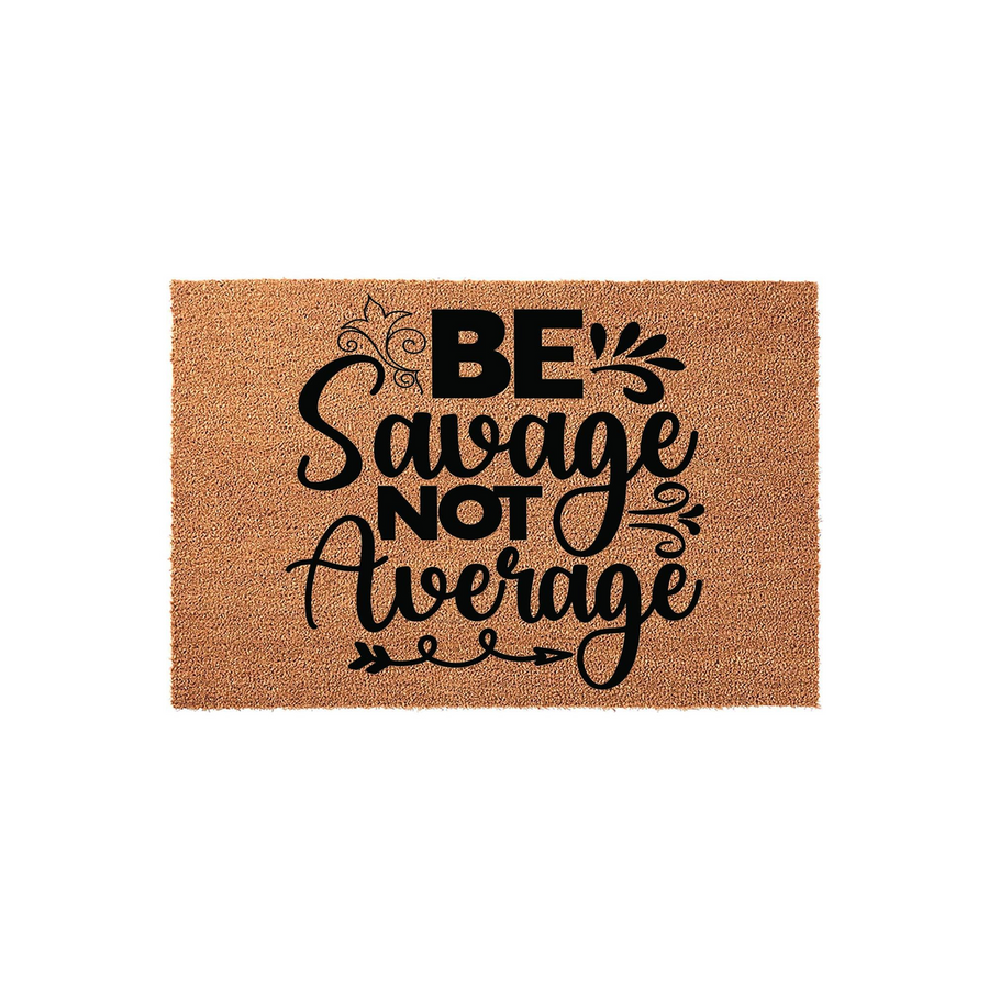 Be Savage Not Average coir doormat featuring bold black typography and decorative flourishes on a natural tan fiber background, creating a stylish and motivational entryway accent for your home decor on a plain white studio