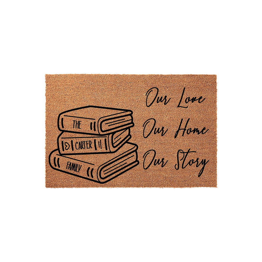 Personalized Book Lover Doormat featuring a stack of three illustrated books with custom family name text, set against a natural coir background with the script phrase Our Love, Our Home, Our Story printed in bold black ink.