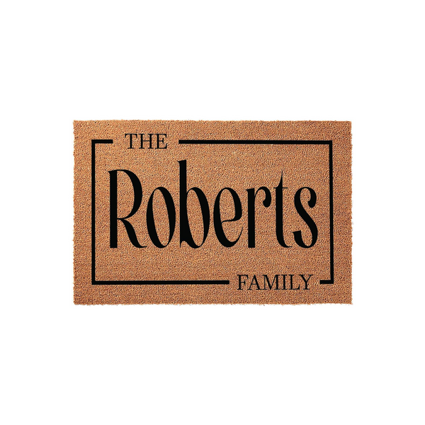 Personalized family name coir doormat featuring a classic rectangular border design with elegant black lettering on a natural tan fiber background, creating a welcoming entrance for any home or housewarming celebration.