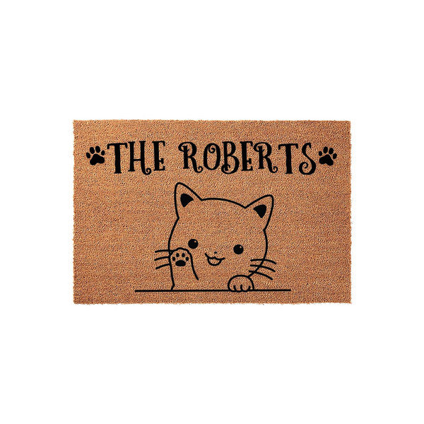 Personalized cat doormat featuring a cute illustrated kitten peeking over a line with its paw raised, set against a natural coir background with customizable family name text and decorative black paw prints on either side.