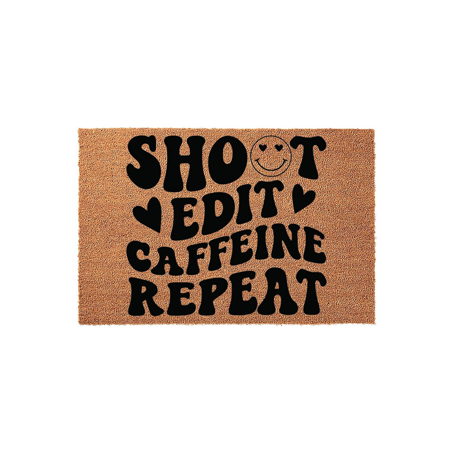 Shoot Edit Caffeine Repeat coir doormat featuring bold black typography and a smiley face icon on a natural tan fiber background, creating a fun and functional entryway decor piece for photographers or creative professionals.