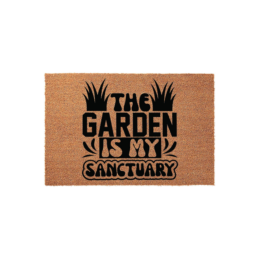 The Garden Is My Sanctuary coir doormat features a natural tan fiber texture with bold black lettering and stylized grass illustrations, making it a charming outdoor welcome mat for any home entrance or patio space.
