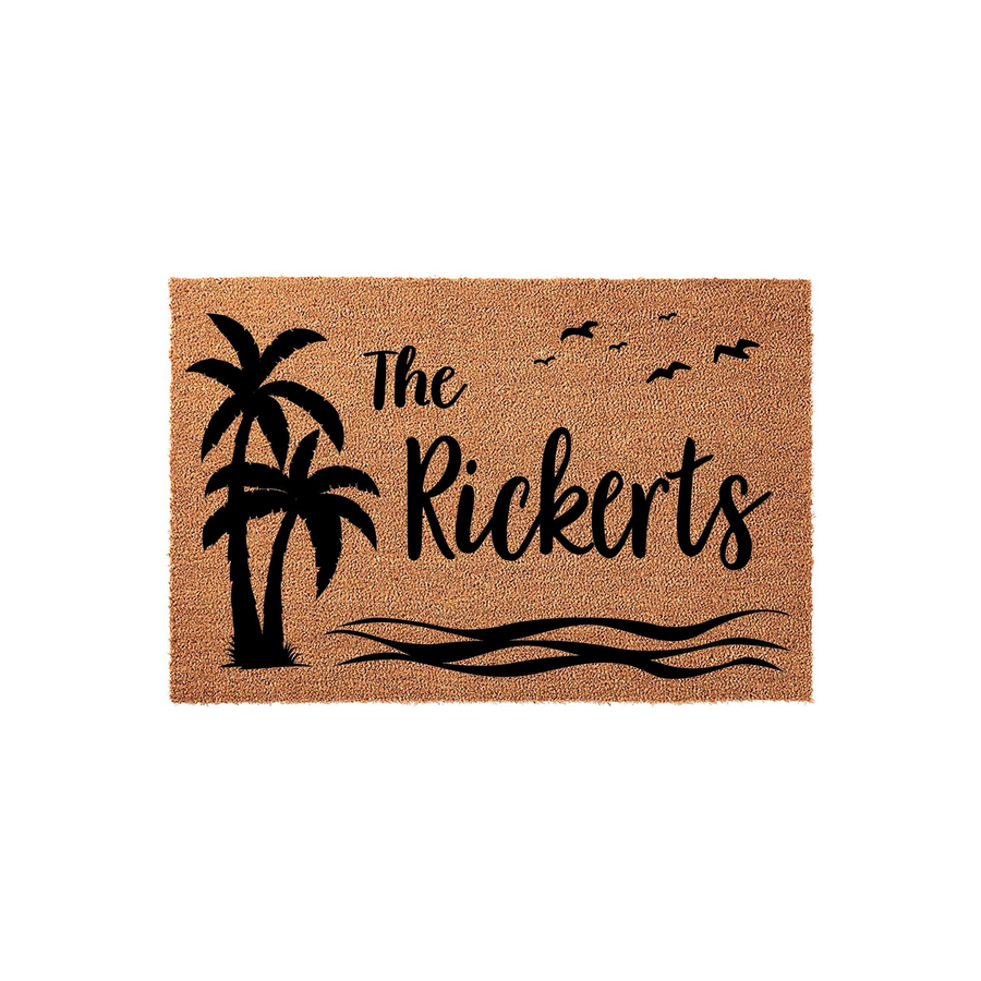 Personalized tropical palm tree doormat featuring a natural coir texture with black ink graphics of a palm tree, ocean waves, and flying birds, customized with a family name in elegant script lettering on a clean white background.