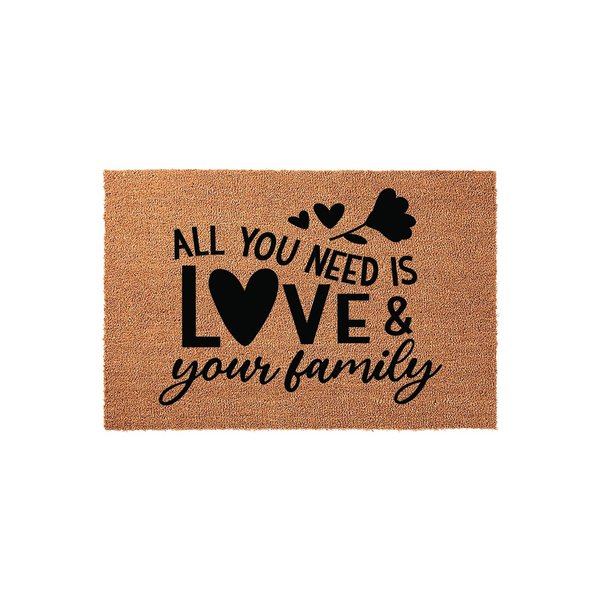 All You Need Is Love and Your Family coir doormat featuring a natural brown fiber texture with bold black text and a decorative heart and flower design, creating a warm and inviting entrance for any home or front porch decor.