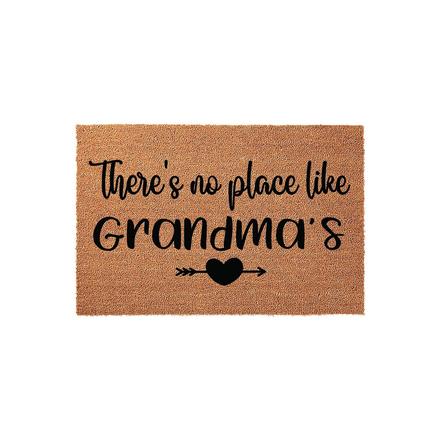 Grandma coir doormat featuring the text There is no place like Grandma's in black script lettering, accented by a small heart and arrow icon on a natural brown fiber background for a welcoming front porch entrance decor style.