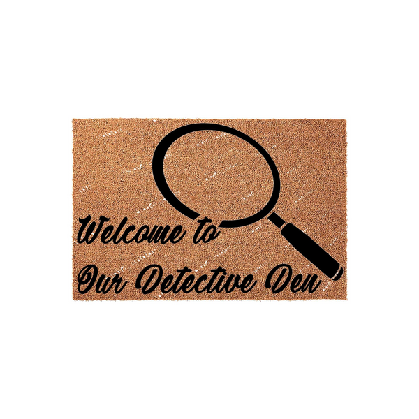 Detective Den Welcome Doormat featuring a natural coir texture with a large black magnifying glass graphic and the text Welcome to Our Detective Den printed in a bold, elegant script font on a plain white studio background.