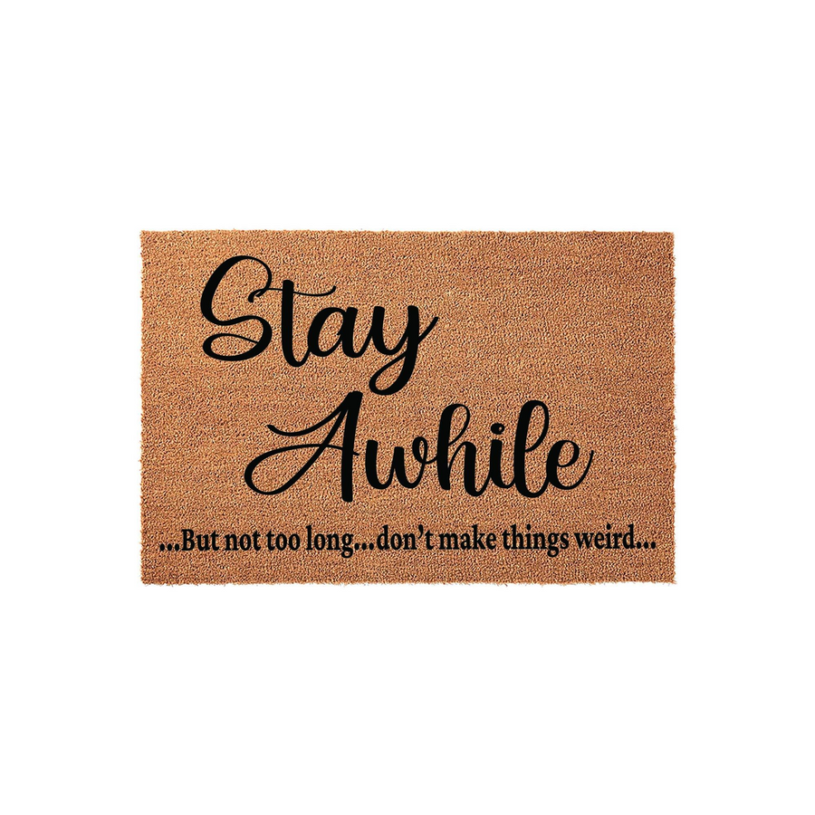Funny Stay Awhile doormat made of natural coir fiber with a rectangular shape, featuring black script and serif text that reads Stay Awhile but not too long, don't make things weird, set against a clean white studio background.