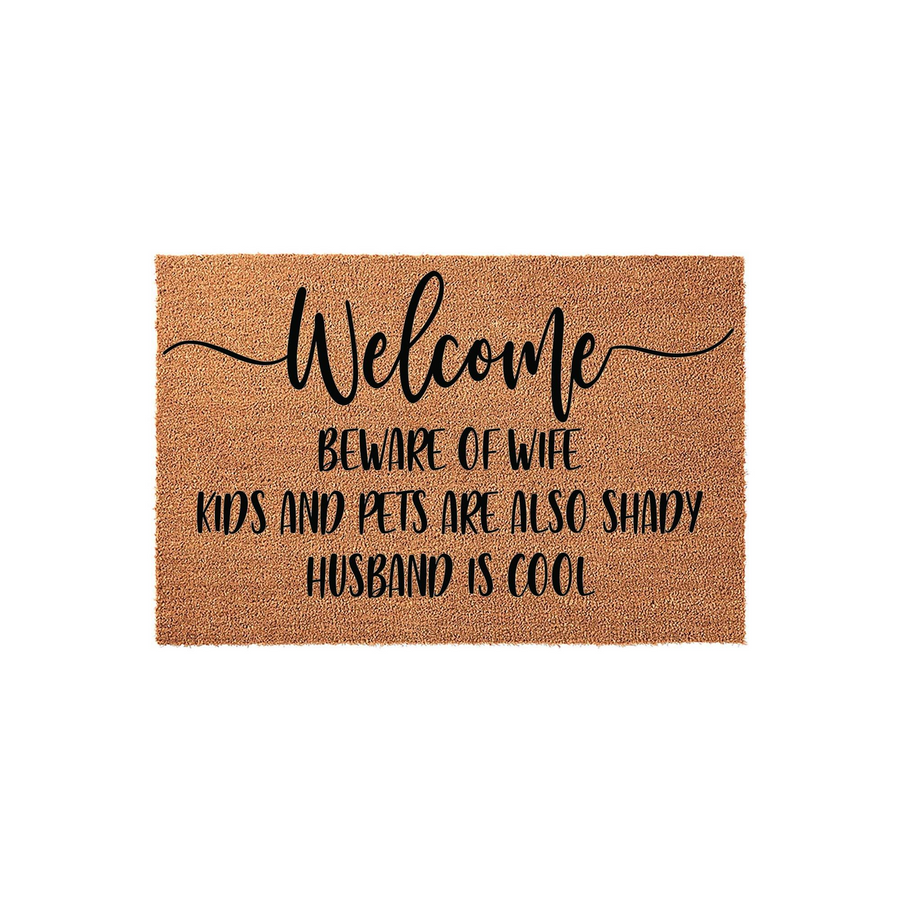 Funny Welcome Doormat featuring a natural coir texture and black text that reads Welcome, Beware of Wife, Kids and Pets are also Shady, Husband is Cool, making it a humorous front porch decor piece for a family home with a