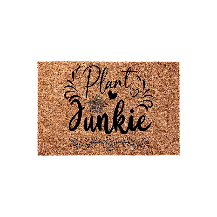Plant Junkie coir doormat featuring a natural tan fiber texture with black printed text and decorative botanical illustrations of a potted plant, hearts, and floral vines centered on a clean white background for a modern home