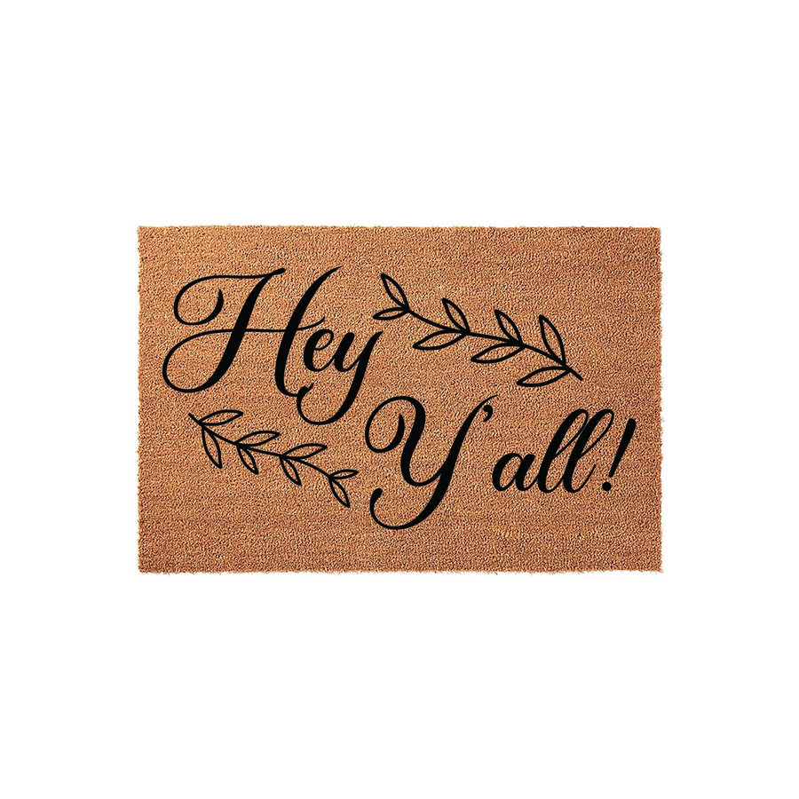 Hey Y'all Coir Doormat featuring a natural brown fiber texture with black script lettering and decorative leaf accents, providing a welcoming and rustic farmhouse aesthetic for your front porch entryway or home doorstep decor.