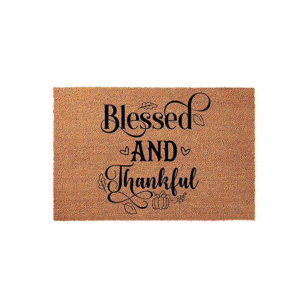 Blessed and Thankful coir doormat featuring black script lettering, decorative hearts, and small pumpkin illustrations on a natural brown fiber background, perfect for a cozy fall porch or autumn home entrance decor.