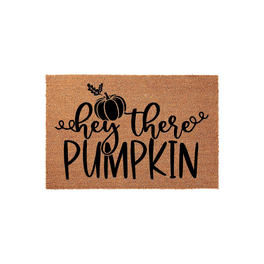 Hey There Pumpkin coir doormat featuring a natural brown fiber texture and bold black lettering with a cute pumpkin illustration, making it a festive fall outdoor welcome mat for your front porch decor during the autumn season.