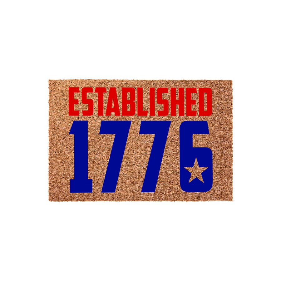 Established 1776 patriotic doormat featuring bold red and blue text on a natural coir fiber background, showcasing a classic American flag-inspired design with a star detail inside the number six for a festive front porch