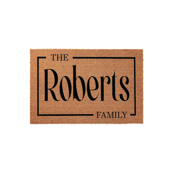 Personalized family name coir doormat featuring a classic rectangular border design with elegant black typography on a natural tan fiber background, creating a welcoming entrance for any home or housewarming celebration.